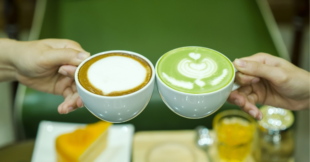 Egyik kéz kávét, a másik matcha lattét tart, a matcha vs kávé összehasonlító cikkhez